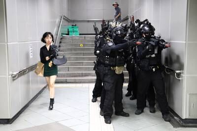 SEOUL, SOUTH KOREA - AUGUST 22: A woman walks past as South Korean soldiers participate in an anti-chemical and anti-terror exercise as part of the 2023 Ulchi Freedom Shield (UFS) at subway station on August 22, 2023 in Seoul, South Korea. The 11-day exercise, which features drills including the handling of chemical and biological attacks, is a regular joint exercise between U.S. and South Korean troops. The exercise serves as a platform for the South Korean government to prepare for potential emergencies on the Korean Peninsula, with some 580,000 officials from about 4,000 city, county and ward governments, public institutions and others across the nation participating. (Photo by Chung Sung-Jun / Getty Images)