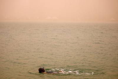 April 7, 2012 (Abu Dhabi) Salem Ali takes a morning swim as a sand storm blankets Abu Dhabi April 7, 2013. (Sammy Dallal / The National)