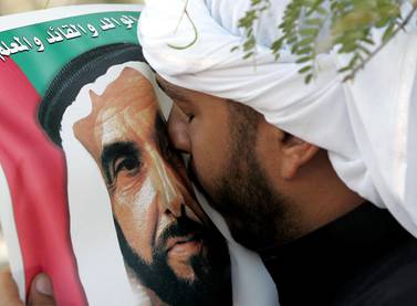 Ein Mann aus den Emiraten küsst während seiner Beerdigung ein Bild von Sheikh Zayed.  Rabih Moghrabi / AFP 