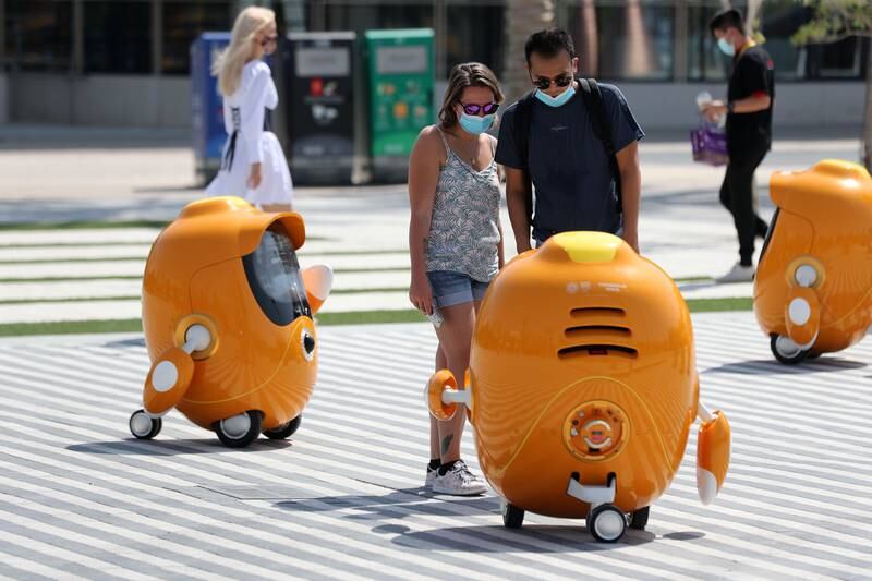 People interact with wandering robots on the first day of Expo 2020 in Dubai. Chris Whiteoak / The National