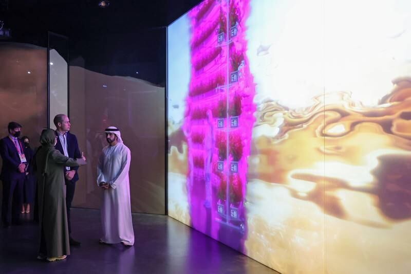 Prince William watches a display inside the UAE Pavilion, accompanied by Sheikh Hamdan bin Mohammed and Noura Al Kaabi. Getty