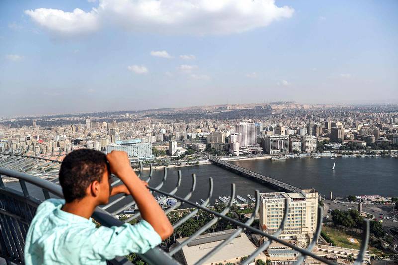 A boy looks from the observation deck of the Cairo Tower in the centre of the Egyptian capital on October 23, 2019, at a view of the Nile river flowing through the city between the central downtown (background) and Zamalek districts (foreground).  / AFP / Mohamed el-Shahed
