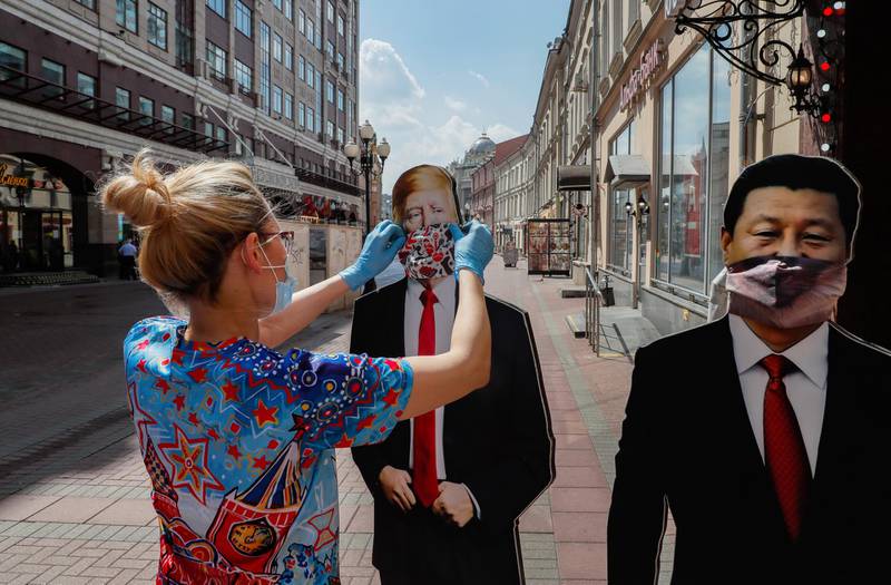 epa08472907 Gift shop salesperson sets cardboards depicting US President Donald Trump (L) and Chinese President Xi Jinping on the street after reopening the shop in Moscow, Russia, 08 June 2020. Moscow authorities have eased coronavirus restrictions. Moscow Mayor Sergei Sobyanin allowed the opening of parks and announced a resumption of work of industrial and construction enterprises.  EPA/YURI KOCHETKOV