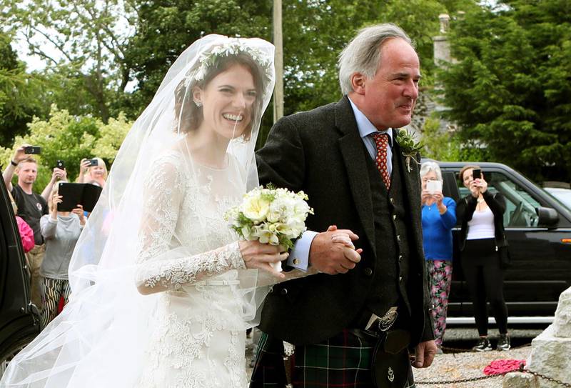 Rose Leslie is escorted by her father Sebastian as they arrive for her wedding at Rayne Church.  Jane Barlow / PA via AP
