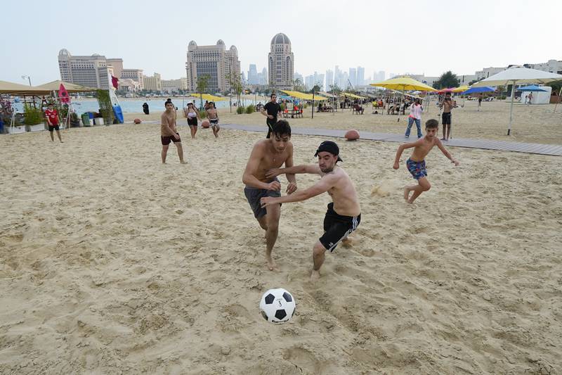 Players tussle for the ball at Katara Beach in Doha. AP