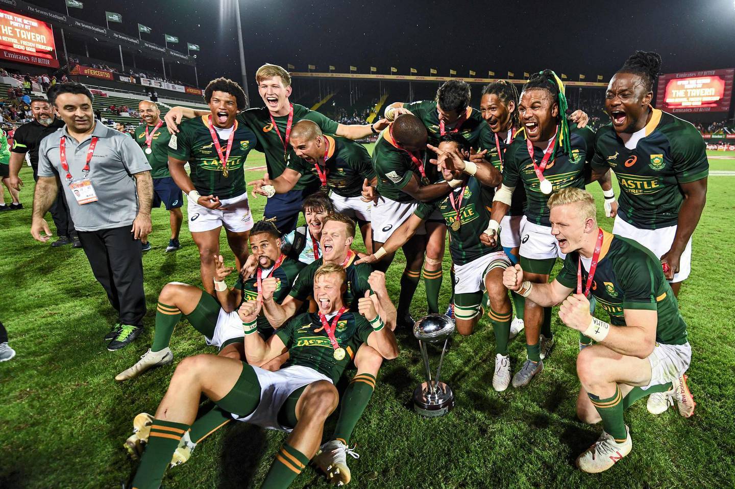Members of the South Africa men's team pose for a picture as they celebrate with the trophy after winning the HSBC Dubai Sevens Series men's cup, at The Sevens Stadium in Dubai on December 7, 2019.  / AFP / KARIM SAHIB
