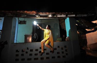 A villager girl switches on a light powered by solar energy in the village of Morabandar on Elephanta Island, off the coast of Mumbai in western India on late night December 20, 2010.Three villages on the island, which is home to the Elephanta Caves UNESCO World Heritage Site, are being provided with round-the-clock electricity for the first time as part of a scheme launched by an Australian firm, Solar-Gem.Fast-growing India wants to become a world leader in the solar power sector and aims to source 20,000 megawatts of electrcity from the sun by 2022 to meet its growing energy needs, ensure security of supply and tackle climate change. AFP PHOTO / Sajjad HUSSAIN / AFP PHOTO / SAJJAD HUSSAIN