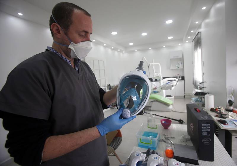 A volunteer dentist works on converting a snorkel mask into a respirator, using 3-D printing technology, to reinforce hospitals and help patients suffering from the coronavirus in Algiers, Algeria April 15, 2020. Reuters