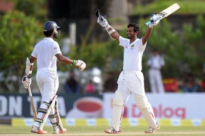 Sri Lanka bastmsan Dimuth Karunaratne celebrates a century on Wednesday during Day 1 of the first Test against West Indies. Lakruwan Wanniarachchi / AFP / October 14, 2015  