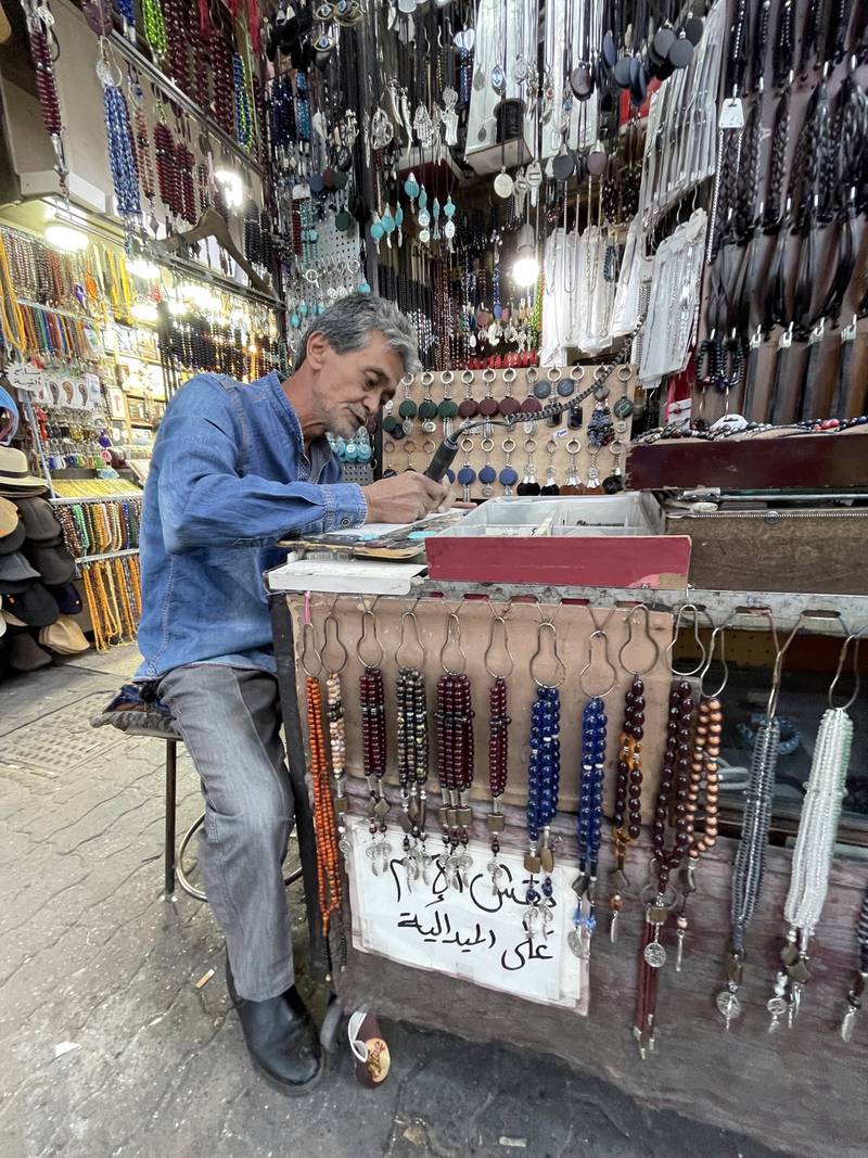 Calligrapher Ahmad Abdulghani working at his tiny shop at the entrance of Bukhara market in Amman. 