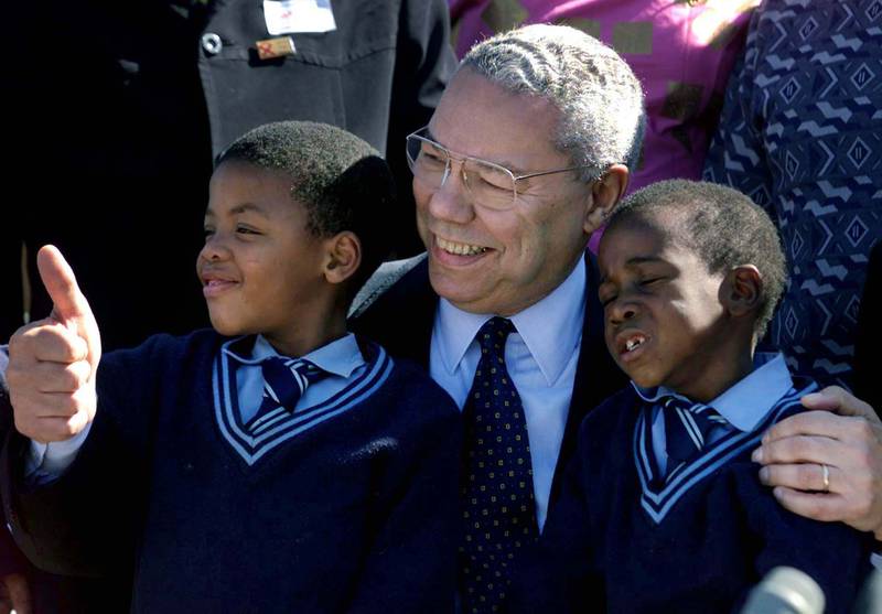 Powell embraces Prince Malika, 6, and Nhlahla Zonke, 7, who are suffering from HIV/AIDS at the Jabavu Clinic in Soweto, South Africa in May 2001. Reuters