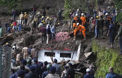Rescuers remove debris as they search for people feared trapped after a landslide near Shimla, Himachal Pradesh. AP