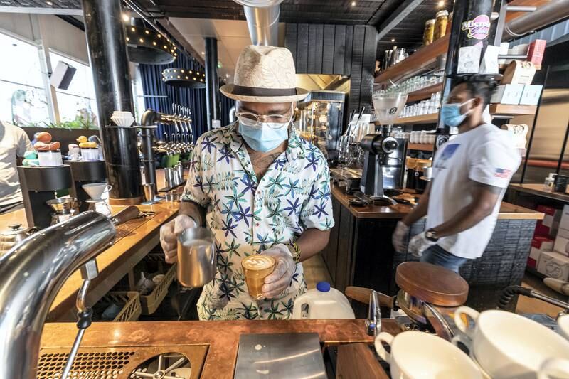 DUBAI, UNITED ARAB EMIRATES. 08 JUNE 2020. Staff at Nightjar Coffee in Al Serkal Avenue, Al Quoz follow strict sanitary procedures due to the current COVID-19 Pandemic to ensure health and safety measures put in place by Dubai Municipality is adhered to. Fresh coffee is made on sight for patrons with the barista wearing a face mask, gloves and sanetizing the work area. (Photo: Antonie Robertson/The National) Journalist: None. Section: National.