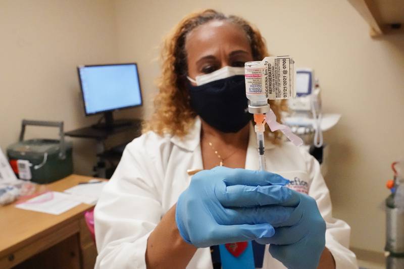 A nurse prepares a dose of the Moderna vaccine. AP 