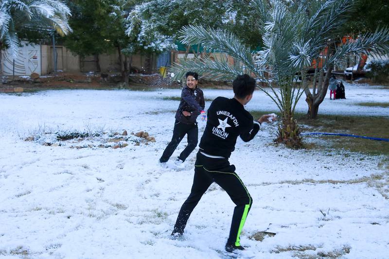 Iraqi boys play with snow in the holy Shiite city of Karbala on February 11, 2020. - Iraq's capital Baghdad woke up covered in a thin layer of fresh snow, an extremely rare phenomenon for one of the world's hottest countries. Snow also covered the Shiite holy city of Karbala further south and Mosul in the north, where heavier precipitation left a blanket of snow over the city's centuries-old ruins. (Photo by Mohammed SAWAF / AFP)
