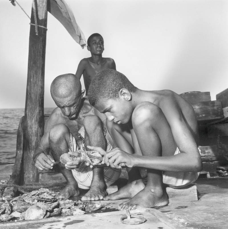 July 1969:  Pearl fishers in Bahrain opening oyster shells.  (Photo by Caltex/Three Lions/Getty Images)