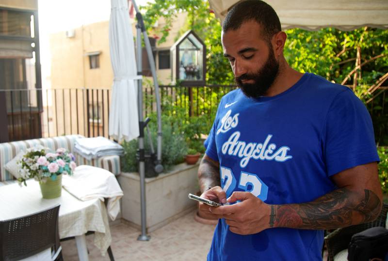 Lebanese trainer Ramzi Baaklini, who was injured during last year's Beirut port blast, holds a phone in Baabda, Lebanon.
