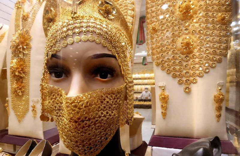 A mannequin bust in a jewelry shop window is adorned with a gold mask and headdress for women at at the Dubai Gold Souk in the Gulf emirate, on March 10, 2021. / AFP / Karim SAHIB
