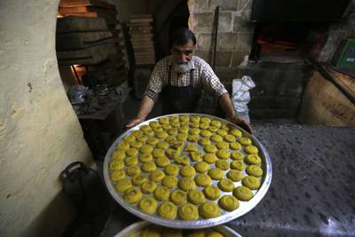 Palestinian baker works to prepare traditional kahk called (Ma'amoul ) inside an old bakery in the old city of Nablus in preparation for Eid Al Adha in the West Bank city of Nablus. EPA
