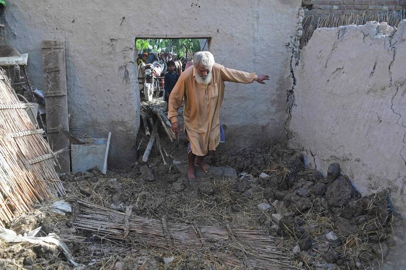 Ghulam Rasool wades through his flood-damaged mud house in Sukkur, Sindh province. AFP