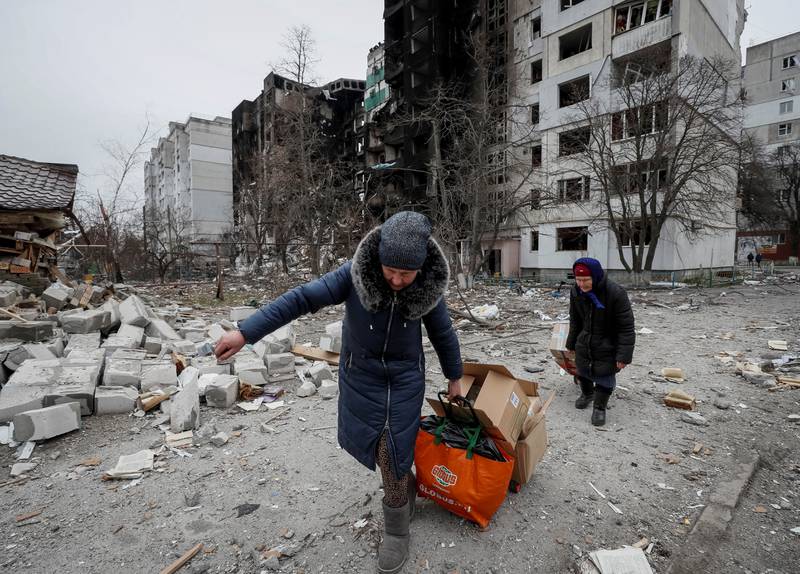 Borodyanka residents carry humanitarian aid packages. Reuters