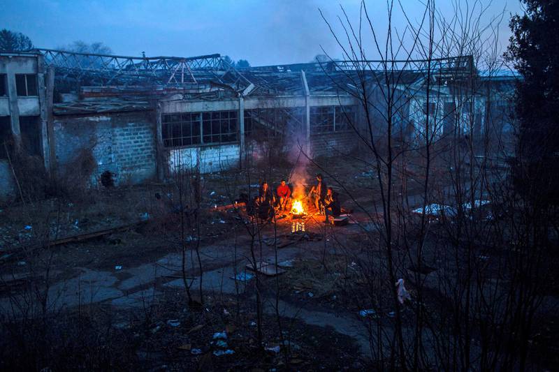 A group of Afghan migrants warm up in a bonfire next to an abandoned factory in the Bihac industrial area.