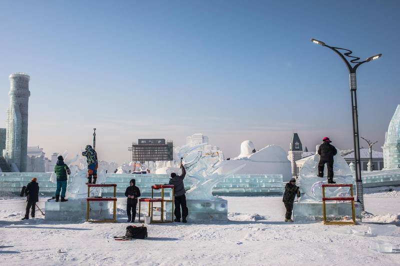 Participants carve their ice sculptures. EPA