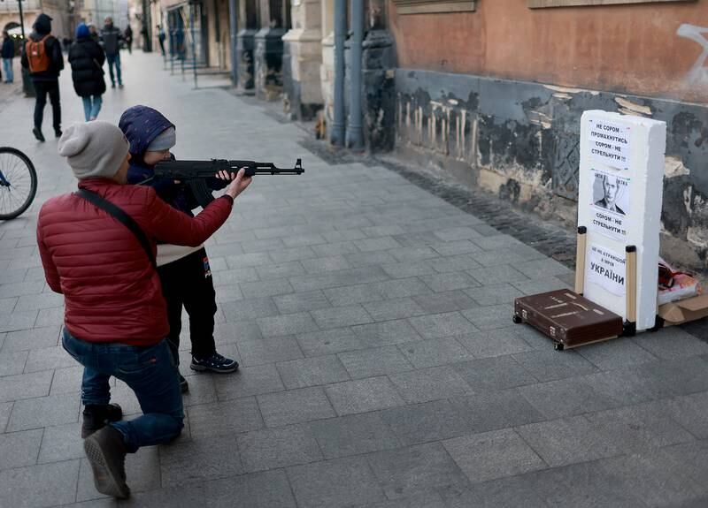 A child uses an air rifle to shoot at a target with the face of Russian President Vladimir Putin in Lviv, Ukraine. Getty