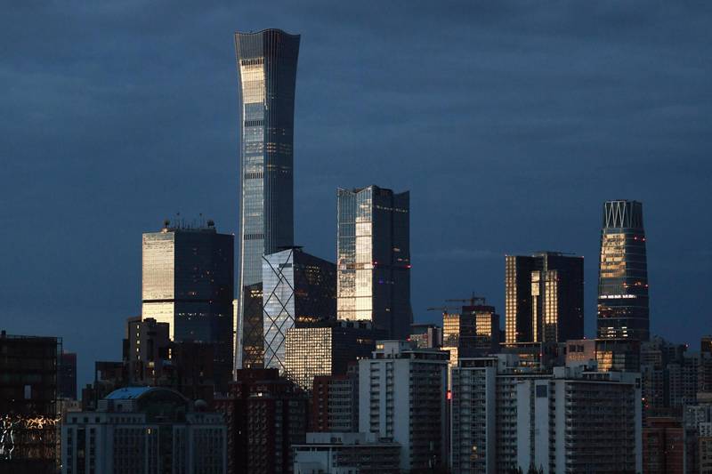 Light reflects off buildings in Beijing's central business district, including the city's tallest building, known as China Zun, at dawn on July 6, 2019. (Photo by GREG BAKER / AFP)