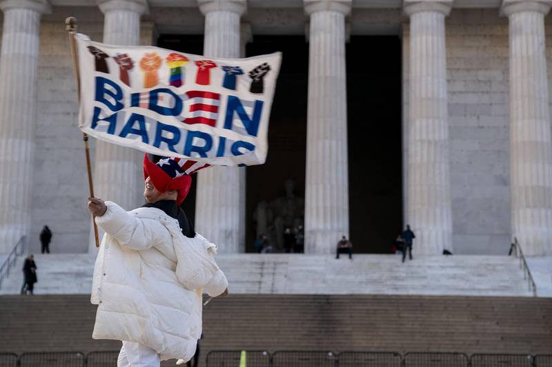 Kyriaki Chris, of Virginia, waves a Biden-Harris flag near the Lincoln Memorial in Washington, DC. AFP