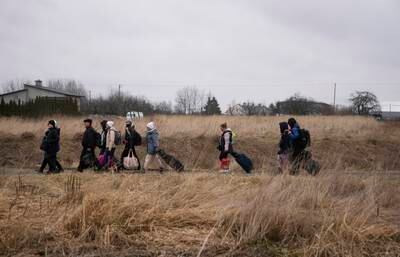 People walk with their belongings as they flee Ukraine. AP Photo / Markus Schreiber
