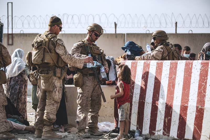 Two US Marines share their water with a young girl during evacuations at Hamid Karzai International Airport, in Kabul, Afghanistan. AP Photo