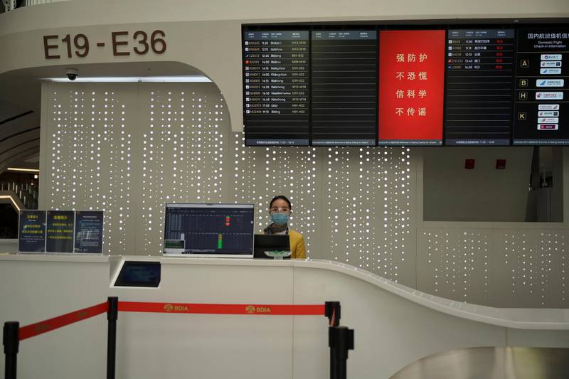 A staff member wearing face mask and goggles is seen at a counter at the Beijing Daxing International Airport, as the country is hit by an outbreak of the novel coronavirus, in Beijing, China February 20, 2020. REUTERS/Tingshu Wang