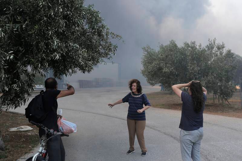 Owners of a honey processing factory react as a bushfire approaches the facility in Aspropyrgos, near Athens, on July 10. EPA