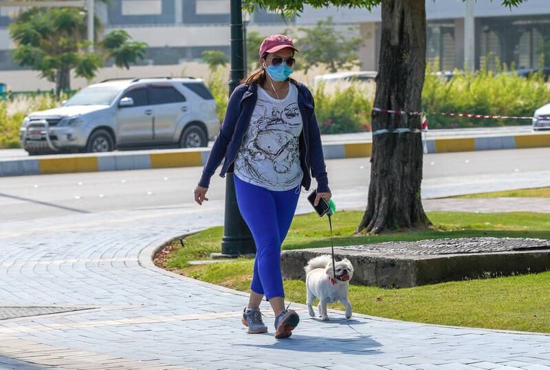 Abu Dhabi, United Arab Emirates, May 27, 2020.  A lady walks her dog on a hazy day along the Corniche, Abu Dhabi.Victor Besa  / The NationalSection:  Standalone / Stock