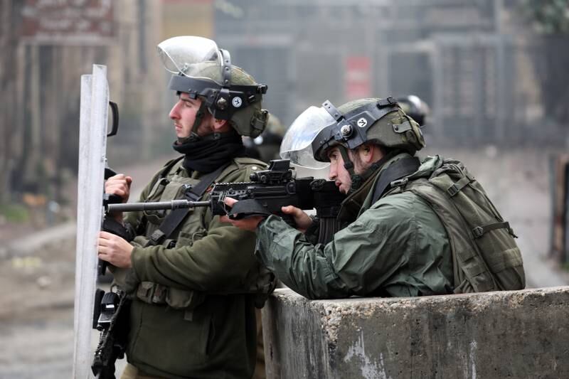 Israeli soldiers take positions during clashes with Palestinians in the West Bank city of Hebron, on March 11. PA