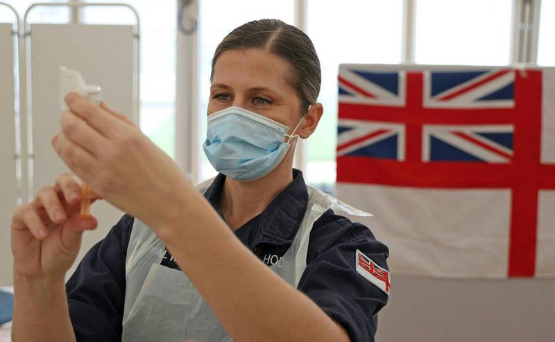 Royal Navy medics prepare syringes at a vaccination centre set up at Bath racecourse. AFP