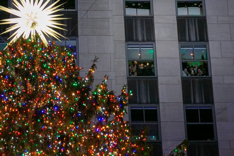 People inside the 40 Rock building take pictures and look at the tree during the 2022 Rockefeller Christmas Tree Lighting Ceremony in New York. EPA