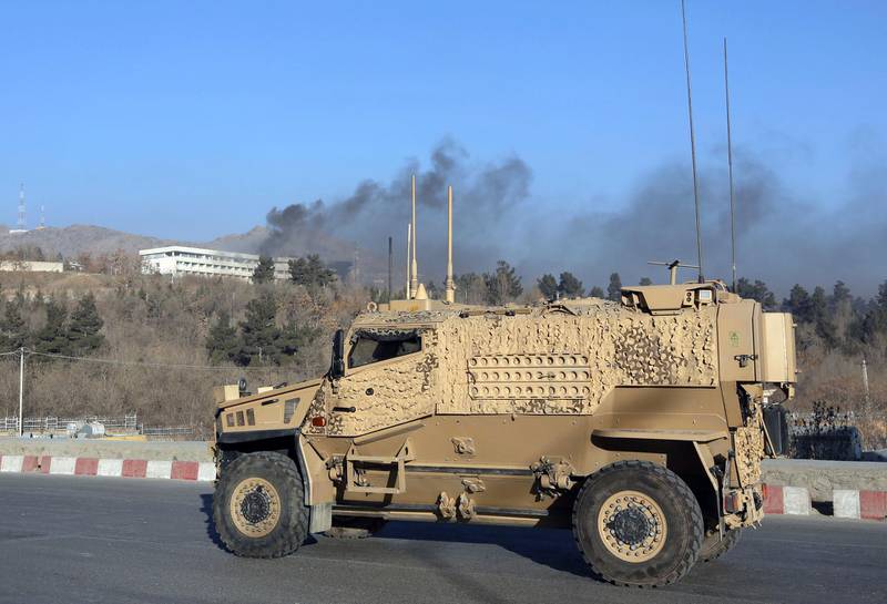 U.S. forces' vehicle arrives s smoke rises from the Intercontinental Hotel after an attack in Kabul, Afghanistan, Sunday, Jan. 21, 2018. Gunmen stormed the hotel and sett off a 12-hour gun battle with security forces that continued into Sunday morning, as frantic guests tried to escape from fourth and fifth-floor windows. (AP Photo/Rahmat Gul)