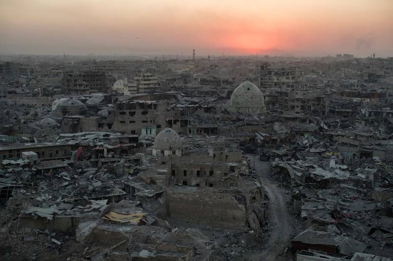 FILE - In this July 11, 2017 file photo, the sun sets behind destroyed buildings in the west side of Mosul, Iraq. The 9-month fight to defeat the Islamic State group in Mosul ended in a crescendo of devastation: bombardment that damaged or destroyed a third of its historic Old City in just three weeks. The cost of uprooting the militants was the destruction of large swaths of Iraq's second largest city, leaving a population that is displaced, exhausted and potentially embittered if there is no reconstruction. (AP Photo/Felipe Dana)