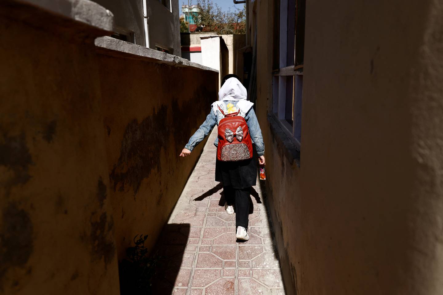 Hadia, 10, a fourth grade primary schoolgirl, walks back from school through an alleyway near her home in Kabul, in October 2021. Reuters