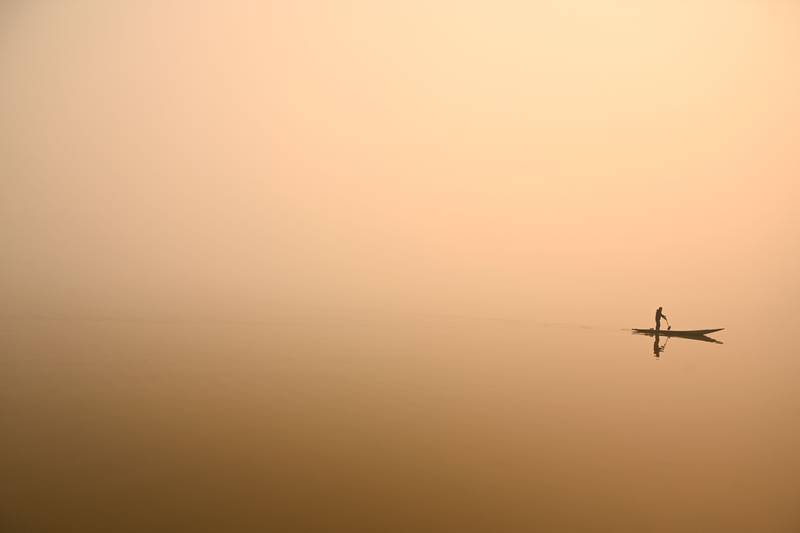 A man steers a boat in Dal Lake amid a thick blanket of fog in Srinagar. AFP
