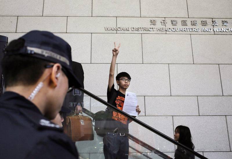Student leader Joshua Wong flashes a victory sign as he arrives at the police headquarters in Hong Kong. Vincent Yu / AP Photo