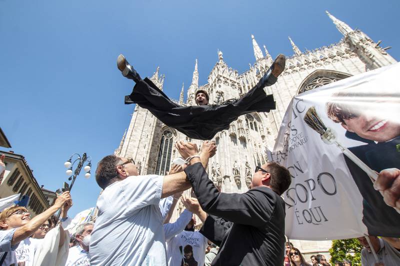 A newly ordained priest is thrown in the air in celebration in front of Milan's gothic cathedral, Italy, Saturday, June 11, 2022.  (Ermes Beltrami / LaPresse via AP)