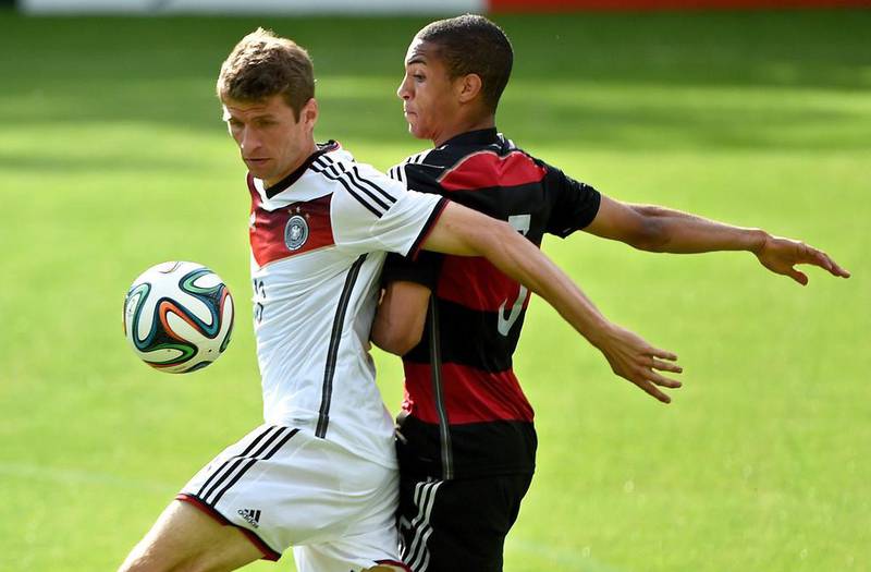 Germany midfielder Thomas Muller, left, and U-20 player Malcolm Cacutalua vie for the ball during Sunday's training game. Patrik Stollarz / AFP