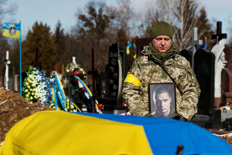 Members of the Honour Guard hold a portrait of a killed member of the Ukrainian Armed Forces during a funeral ceremony in Kyiv. Reuters