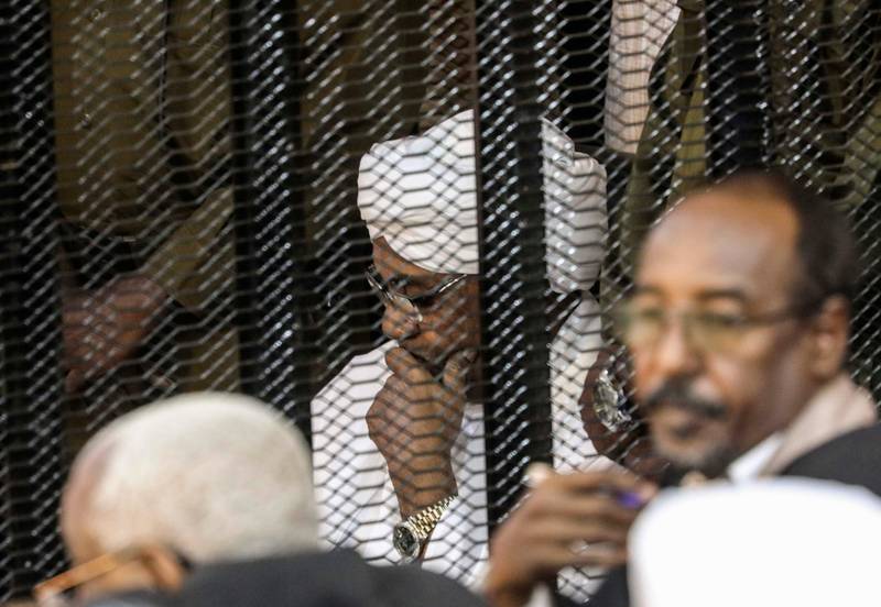 FILE - In this Aug. 24, 2019 file photo, Sudan's autocratic former President Omar al-Bashir sits in a cage during his trial on corruption and money laundering charges, in Khartoum, Sudan. A top Sudanese official said Monday, Feb. 11, 2020, that transitional authorities and rebel groups have agreed to hand over al-Bashir to the International Criminal Court for war crimes, including mass killings in Darfur. Since his ouster in April, al-Bashir has been in jail in Sudanâ€™s capital, Khartoum over charges corruption and killing protesters. (AP Photo, File)