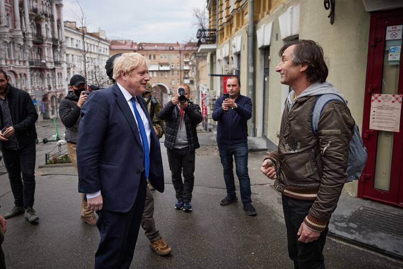 British Prime Minister Boris Johnson, left,  speaks with a resident as he walks with Ukrainian President Volodymyr Zelenskyy in central Kyiv. AFP
