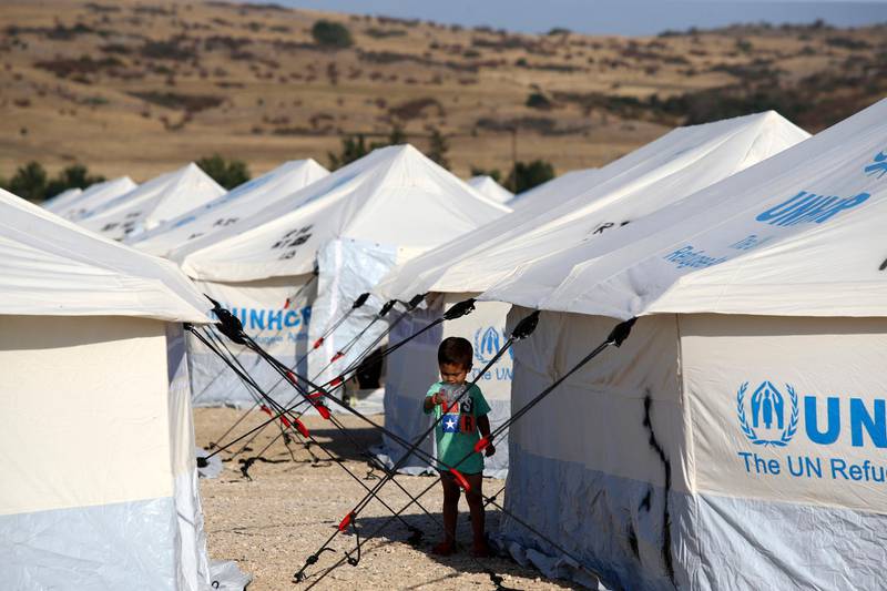 A migrant boy stands outside a tent at a refugee camp in Nea Kavala, northern Greece.  About 1,500 asylum-seekers transported from Greece's eastern Aegean island of Lesbos to the mainland. Around 1,000 of those transferred and housed in Nea Kavala, where they will be staying in tents until the end of the month, after which they will be transferred to a new camp under construction.  AP