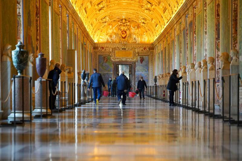 Museums employee walk down an aisle of the Vatican Museums as they prepare to open. AP Photo